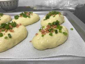 葱花和香肠先加植物油搅拌均匀，面团上刷一层全蛋液后撒上葱花和香肠