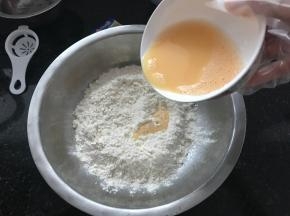 高筋面粉和低筋面粉混合，倒入前面调好的水。