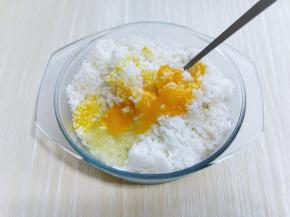 取一个鸡蛋黄放入剩米饭中，搅拌均匀，（最后选用剩米饭做炒饭，这样炒出来口味比较好，颗粒感也特别明显。）