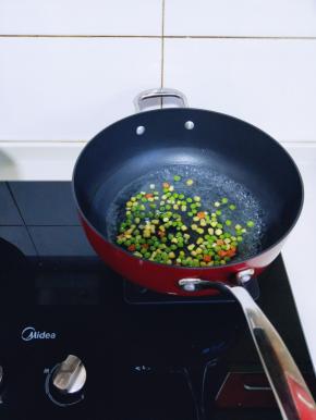 将玉米粒，胡萝卜丁，青豆焯水，锅中加入清水烧开后，将三种食材倒入锅中，大火焯水2分钟捞出备用。