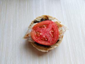 放一片切好的番茄，再放一片奶酪！把切下来的汉堡胚盖在上面即可。