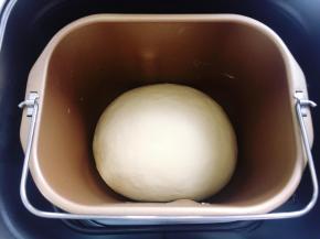 盖上面包机盖子，让面团在26度的室温环境下发酵至两倍大，用手指沾干粉在面团中间戳一个洞，不回缩不塌陷就表示发酵到位。