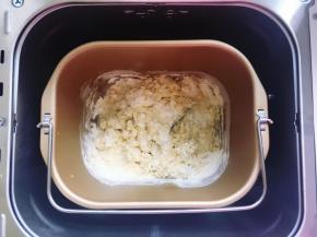 首先将面粉、小苏打和无铝泡打粉混合均匀，然后放入面包桶里，再加入全蛋液、盐和120克清水，用筷子搅拌到无干粉状态，剩余的20克水视情况再加，加到合适为止。