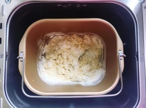 首先将面粉、小苏打和无铝泡打粉混合均匀，然后放入面包桶里，再加入全蛋液、盐和120克清水，用筷子搅拌到无干粉状态，剩余的20克水视情况再加，加到合适为止。