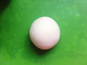 然后从面包桶里取出面团，用手搓圆。