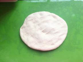 将面团用手摊开，并用手掌不停地按压面团，两分钟后将面团揉成圆形，盖上保鲜膜，醒发10分钟。10分钟后，再将面团用手摊开，用手掌不停地按压面团，然后继续醒发10分钟，再重复一次前面的步骤，一共醒发三次。