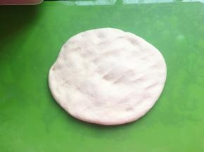 将面团用手摊开，并用手掌不停地按压面团，两分钟后将面团揉成圆形，盖上保鲜膜，醒发10分钟。10分钟后，再将面团用手摊开，用手掌不停地按压面团，然后继续醒发10分钟，再重复一次前面的步骤，一共醒发三次。