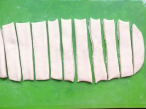 然后用刮板切成宽度相等的长条形，比锅子短的尺寸即可，否则炸的时候面胚长了，锅子小了就不合适。