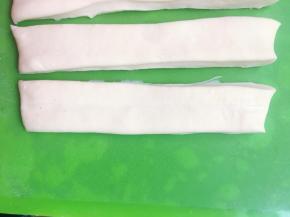 将两条长条形的面胚重叠在一起，两条面胚之间可以沾点水，这样粘的更紧实，炸的时候不容易散开。