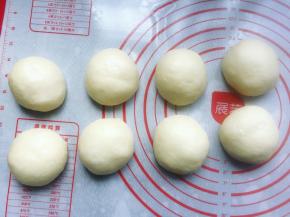 将发酵好的面团取出，轻拍排气，称重后分成8个均等的小剂子，并用手滚圆，然后盖上保鲜膜松弛15分钟。