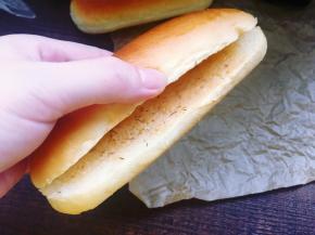 用面包刀从面包的一侧剖开，里面抹上一层法式沙拉酱。