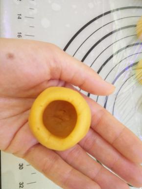 将搓圆的馅料从顶部用食指抠洞，洞要抠成口小里面大，洞要够大才能装上5克流心馅。