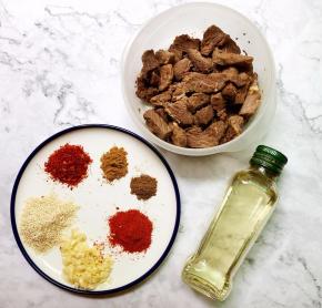 把腌制好的牛肉拿出备好，把需要的配料都备好，有白芝麻，白芝麻要事
先炒香，用干锅炒至芝麻微微发黄有芝麻香味即可，辣椒面，花椒粉，
十三香，辣椒粉，蒜头切成末