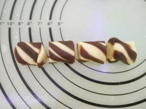 以双色为例,主色面团要比配色面团比例高。将主色面团搓成长条，配色面团搓长分成几份贴在外面，用手扭一扭，分割成15克一个。