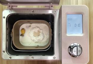 所有材料都称好，除了黄油，其它所有的材料都投进面包机启动和面
功能先选择10分钟，然后看一下状，这时我又增加了10分钟，总共揉了2次