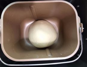 揉圆放进面包机内进行第一次发酵发至1.5倍大,手指先沾上面粉，在面团表
面上戳洞，若孔洞没有回缩就是发酵完成