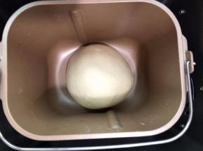 揉圆放进面包机内进行第一次发酵发至1.5倍大,手指先沾上面粉，在面团表
面上戳洞，若孔洞没有回缩就是发酵完成