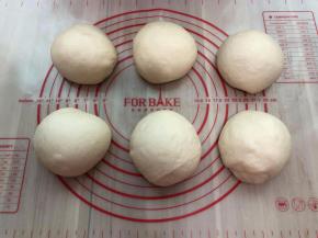 把发酵好的面团取出按压开排气，把面团分成6等份，滚圆后盖保鲜膜松弛20分钟