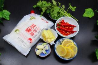 等待鸡爪放凉的过程，可以准备辅料食材。生姜洗净切片、辣椒洗净切段，留2个不要切。柠檬洗净切片，大蒜、葱白、香葱分别洗净准备好。