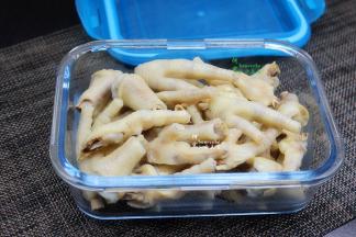 把放凉的鸡爪装入保鲜盒，别装的太满，我分了二个保鲜盒装。然后把柠檬片、辣椒、生姜、大蒜、葱白、香葱、白砂糖、盐，放在鸡爪上面，接着倒入泡椒水、香醋、生抽。液体要浸没鸡爪，这样才入味，不会坏。