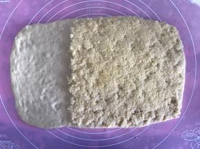 再将椰蓉铺满面团的三分之二处，用刮刀压实椰蓉。