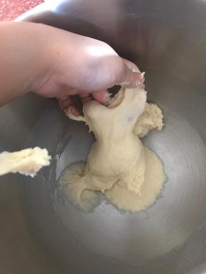 搅打15分钟左右，停下厨师机观察面团组织。面团揉至有延展性和粗膜的时候，加入黄油。