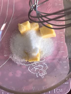 面团发酵的同时，我们可以制作椰蓉馅料。将室温软化的黄油和细砂糖用手动打蛋器搅打均匀。