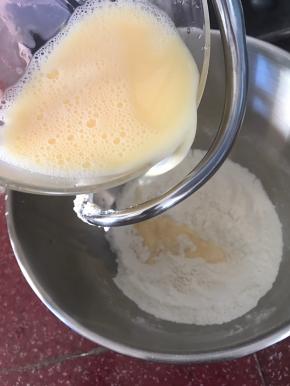 倒入面粉材料中，开2档速度低速搅打均匀。材料混合均匀成团后，开4档搅打面团。