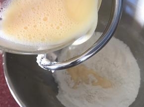 倒入面粉材料中，开2档速度低速搅打均匀。材料混合均匀成团后，开4档搅打面团。