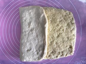 将左边空白处的面团向右边对折，接着再向右边对折，刚好盖起来是个长方形。将周围边边收口，以免椰蓉馅侧漏。收口后再用擀面杖轻轻幹开成长方形状。