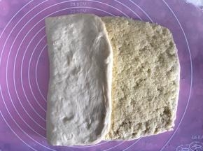 将左边空白处的面团向右边对折，接着再向右边对折，刚好盖起来是个长方形。将周围边边收口，以免椰蓉馅侧漏。收口后再用擀面杖轻轻幹开成长方形状。