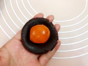 取一份红豆沙压扁包入咸蛋黄