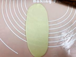 擀成牛舌状，再从上往下卷起