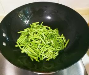 锅中余油放入洗净切成段的芦蒿翻炒片刻