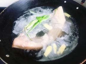 首先将五花肉清洗干净，姜洗净去皮后切片，香葱洗净去根，取两根香葱打一个结，准备两个葱结，锅里倒入适量清水，将五花肉放入冷水锅里，再加入姜片、1个葱结和1大勺料酒，大火煮15分钟。