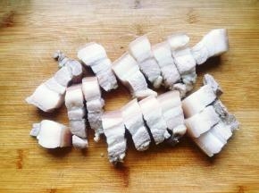 15分钟后捞出烫熟的五花肉，放凉后用刀切成小块。