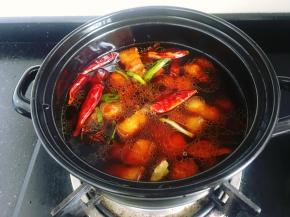 将炒好的五花肉倒入砂锅里，加入200ml花雕酒、和适量清水大火烧开。