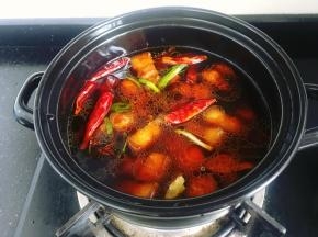将炒好的五花肉倒入砂锅里，加入200ml花雕酒、和适量清水大火烧开。
