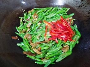 放入红椒丝翻炒15秒