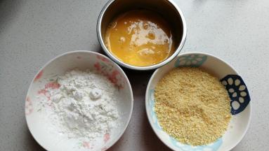 先将鸡蛋两个打入碗中，再调入一点点盐用手动打蛋器搅打均匀，接着再取适量淀粉和适量面包糠放入碗中待用。