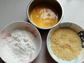 先将鸡蛋两个打入碗中，再调入一点点盐用手动打蛋器搅打均匀，接着再取适量淀粉和适量面包糠放入碗中待用。
