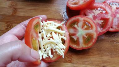 然后取适量的芝士碎放入番茄中夹起来