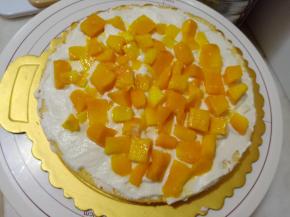 放上一层蛋糕片，抹一层淡奶油，放上一层芒果，再用一层淡奶油抹平芒果。