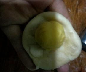 把面团捏成中间后两边薄的酥皮，把地瓜馅包在里面，尽量不要包进空气，光滑的那面朝外