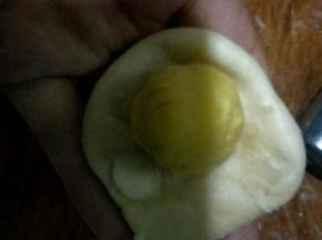 把面团捏成中间后两边薄的酥皮，把地瓜馅包在里面，尽量不要包进空气，光滑的那面朝外