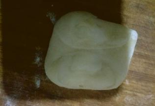 拿一个面团按扁，两头按向中间如图