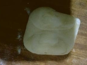 拿一个面团按扁，两头按向中间如图