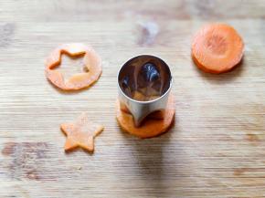 将洗干净的胡萝卜切片，再用模具压出五角星形状。（如果没有模具，可以省略）