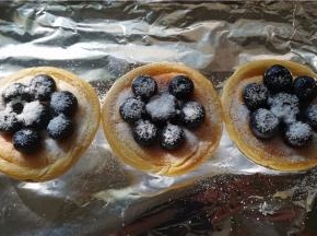 挞上面再用蓝莓粒和糖粉装饰一下