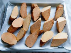 烤盘垫上油纸，依次将切好的红薯角摆放在烤盘中。